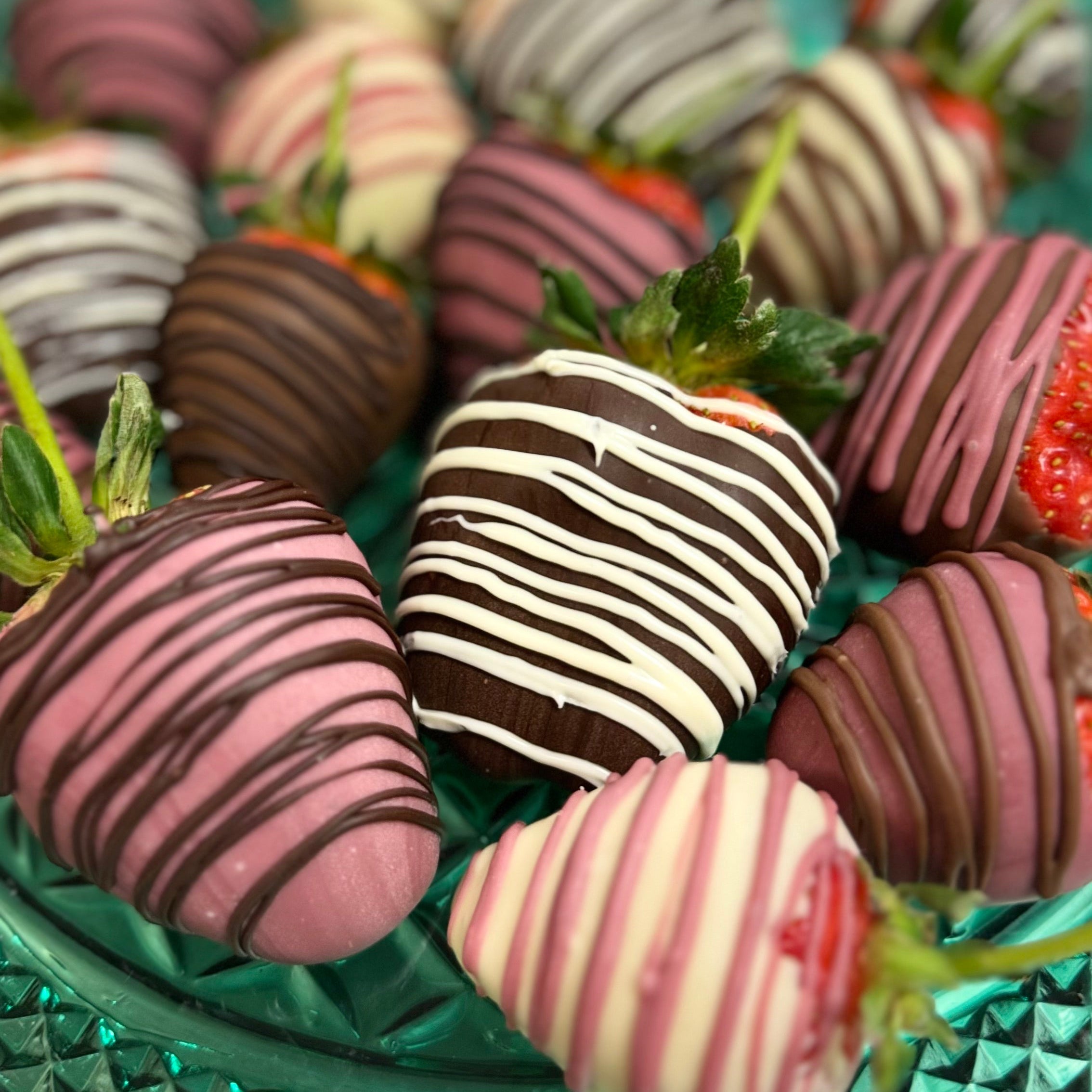 Chocolate-dipped strawberries on a green plate with a blurred background